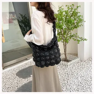 Detail of black puff tote bag with 3D bubble texture and pleated shoulder strap