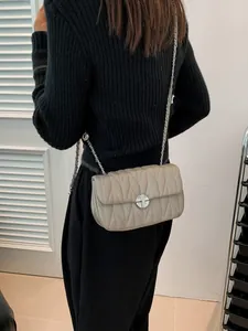 Petit sac bandoulière beige matelassé avec chaîne argentée et motif à chevrons chic