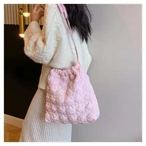 Detail van roze gewatteerde bucket bag met zachte puffertextuur en trekkoordsluiting
