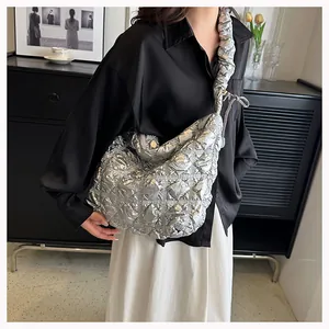 Detail of silver metallic quilted puffer bag with pleated shoulder strap and drawstring