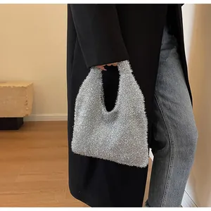 Silver glitter tote bag for women styled with a black coat and casual jeans