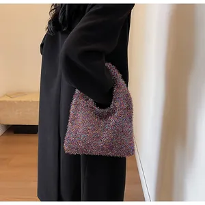 Detail of colorful plush underarm bag with shimmering threads on a black wool coat