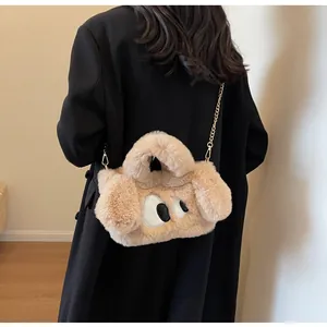 Dettaglio della borsa in peluche a forma di cane con grandi occhi e catena dorata