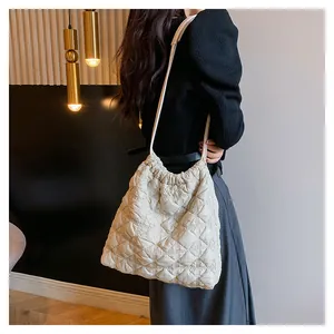 Detail van gewatteerde cloud bucket bag met trekkoord en slanke schouderriem