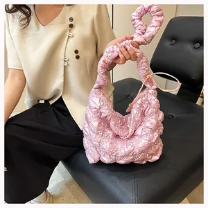 Detail of pink pleated hobo bag showing glossy bubble texture and stylish round handle