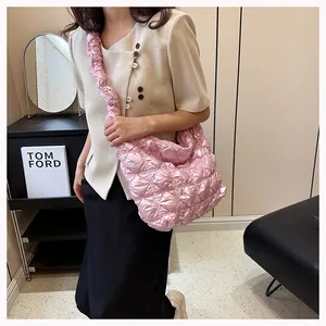 Close-up of pink quilted puffer tote bag featuring soft pleated texture and wide strap
