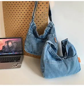 Macro shot of retro denim crossbody bags in two blue shades with orange side labels