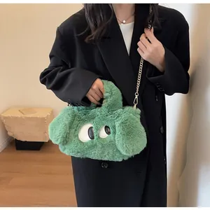 Dettaglio borsa di peluche verde con occhi 3D e catena dorata su abito nero