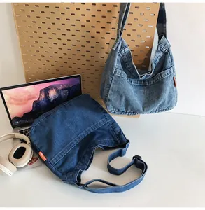 Close-up of light and dark wash denim tote bags with side orange labels and wide straps