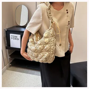 Detail of champagne gold bubble textured quilted tote bag with pleated shoulder strap