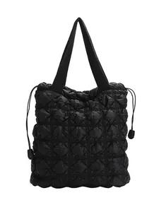 Minimalist black quilted tote bag with bubble texture and drawstring side details