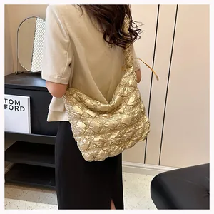 Golden quilted cloud tote bag worn by a model showing a metallic bubble texture design
