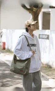 Olive green canvas crossbody bag featuring adjustable straps and outer zipper pocket