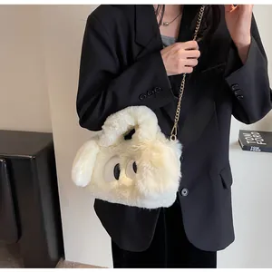 Dettaglio della borsa di peluche crema con grandi occhi e tracolla a catena dorata