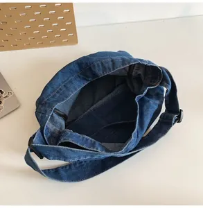 Interior view of deep blue denim crossbody bag showing spacious main compartment