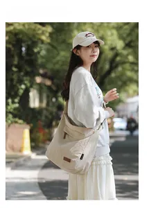 Detail shot of khaki canvas crossbody bag with front flap pocket and leather patch detail