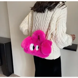 Dettaglio borsa di peluche rosa con grandi occhi a fumetto e tracolla a catena in metallo