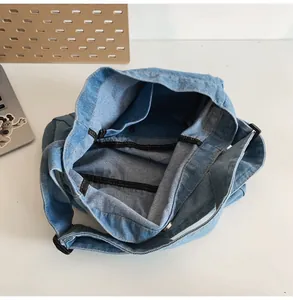 Internal view of a large denim tote bag featuring a metal snap button and inner pocket