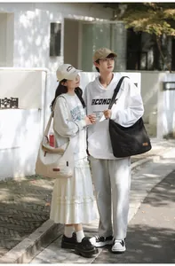 Lifestyle shot of high-capacity canvas crossbody bags in cream and black on a model