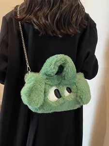 Borsa a tracolla in peluche verde con occhi a fumetto e catena dorata su cappotto nero
