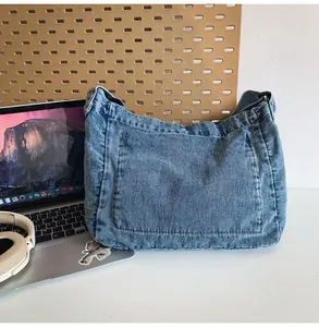 Close-up of vintage blue denim crossbody bag with rugged texture on a desktop
