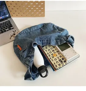Top view of blue denim tote bag showing interior capacity with water bottle and phone