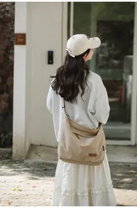 Detail view of khaki canvas tote with zippered pocket and leather logo for daily commute