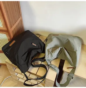 Close-up of lightweight nylon tote bags in black and olive green with leather brand tags