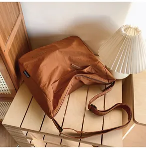 Close-up of caramel canvas messenger bag showing fabric texture and adjustable strap