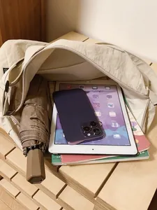 Large off-white canvas crossbody bag with internal storage for iPad and books