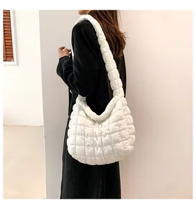 Detailopname van witte gewatteerde puffer schoudertas met zachte vulling op een model