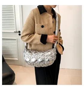 Details der silbernen gesteppten Halbmond-Tasche mit glänzender Textur und Rautensteppung