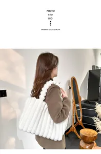 Détail du sac cabas en peluche blanche à rayures verticales porté à l'épaule du mannequin
