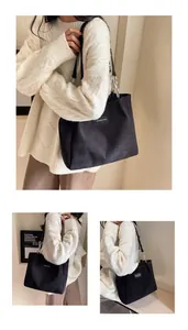 Detalle del bolso tote de pana negra con cadena de metal y etiqueta de moda decorativa
