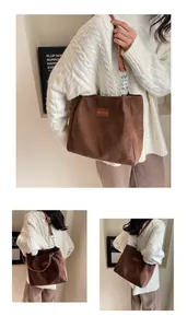 Vista detallada del bolso tote de pana marrón con etiqueta de moda y cadena de metal