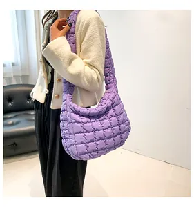 Detail van de paarse gewatteerde cloud bag met zachte nylon textuur en brede schouderband