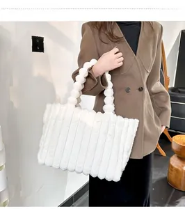 Gros plan détaillé d'un sac cabas en peluche blanche avec une anse à boules duveteuses
