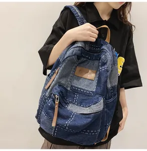 Dettaglio dello zaino in denim patchwork con cuciture a contrasto e patch in pelle