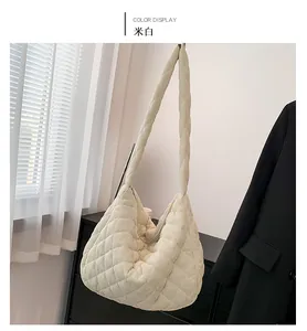 Detailansicht der cremeweißen gesteppten Puffer-Tasche mit Rautenmuster und Reißverschluss
