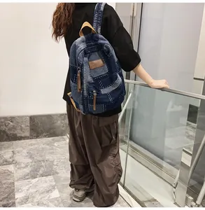 Dettaglio dello zaino in denim patchwork retrò con logo in pelle e cuciture a contrasto