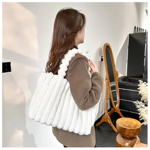 Détail d'un grand sac cabas en peluche blanche avec rayures verticales porté par un modèle