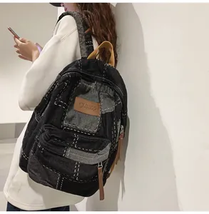 Dettagli dello zaino in denim patchwork con cuciture bianche e logo in pelle vintage