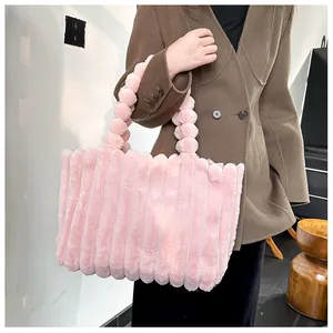 Détail du cabas rose en peluche avec texture plissée et poignée en boules de fourrure