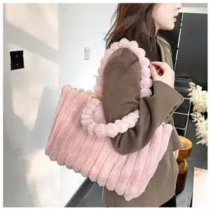 Grand sac cabas rose en peluche à rayures avec poignée à boules porté par le mannequin