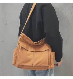 Dettaglio della borsa a tracolla in tela marrone vintage con ampie tasche anteriori e laterali