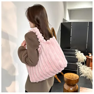 Détail d'un sac cabas en peluche rose avec texture rayée et poignées boules