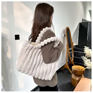 Détail du sac fourre-tout en peluche avec rayures verticales et poignée boule