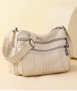 Detail of off-white soft leather shoulder bag with multiple front zipper pockets