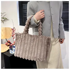 Détail d'un cabas en peluche marron clair avec rayures verticales et poignée bulle