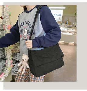 Detail van hartgequilte zwarte crossbodytas met een schattige roze pluche berenclip